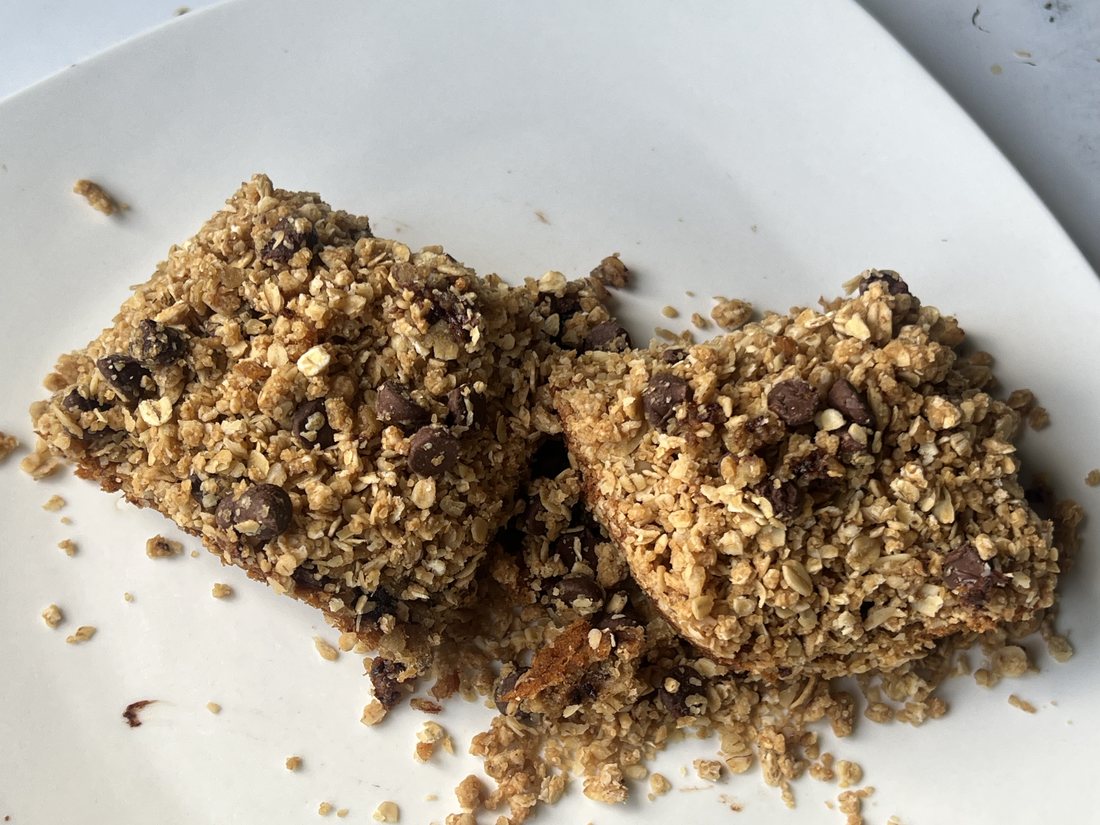 Two Megan Bars on a white plate, oat crumble and chocolate chips on top
