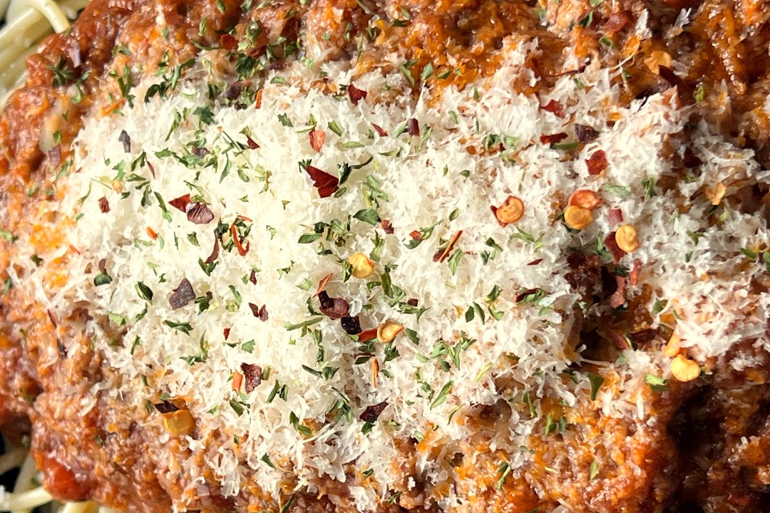 Our spaghetti bolognese, close up: parmesan, chilli flakes and herbs